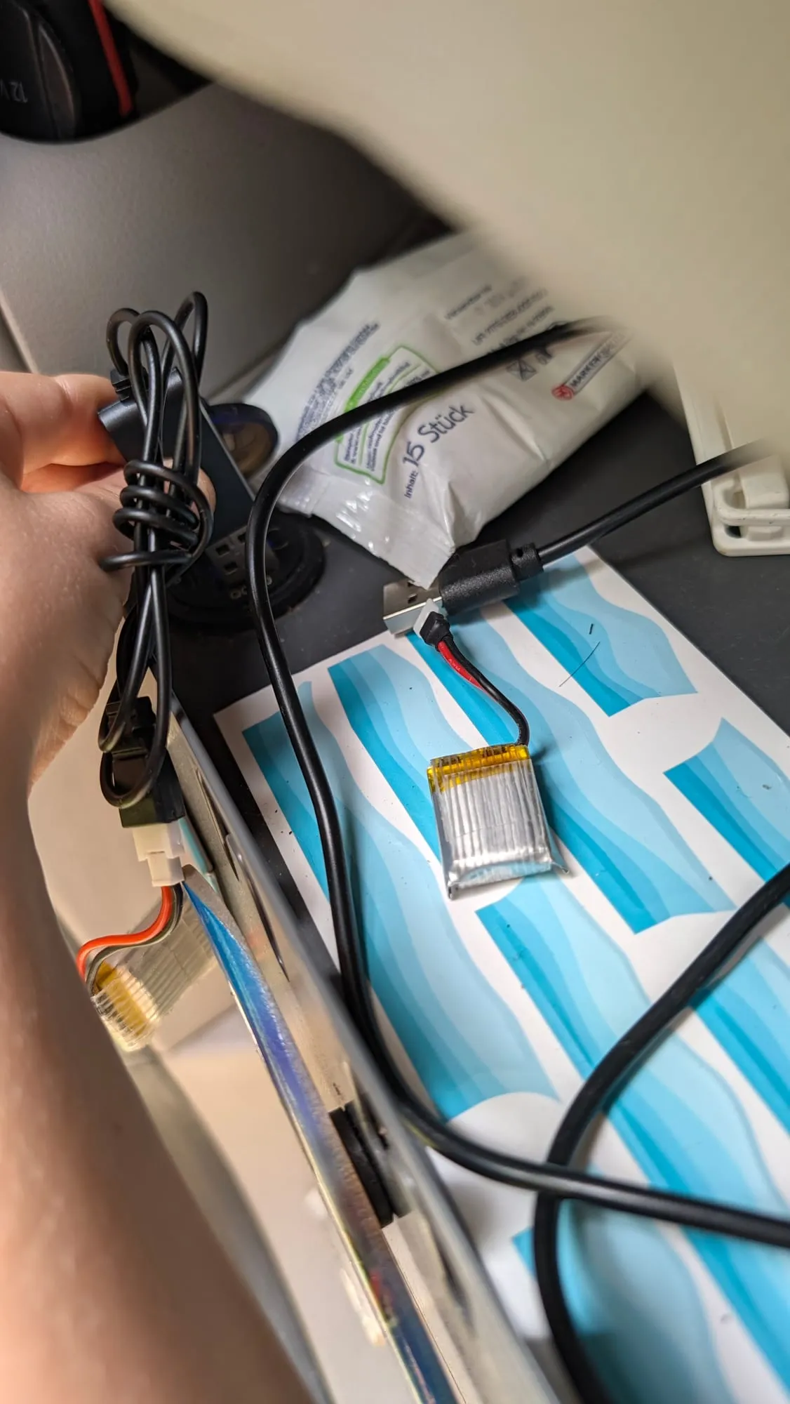 Nahaufnahme der Ladetechnik für die RC-Fahrzeuge: Akku und Ladekabel liegen griffbereit in der Box