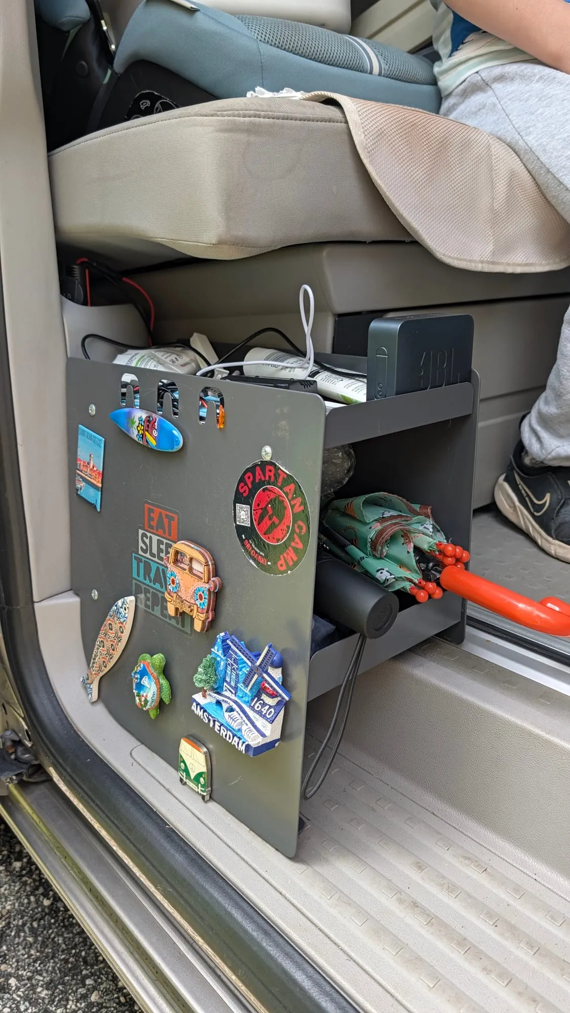 Die Seitenbox am Eingang des Busses, außen mit Aufklebern von gemeinsamen Reisezielen verziert, obendrauf eine Musikbox