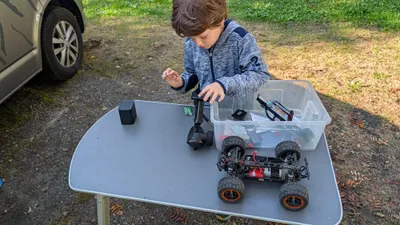Mio repariert einen RC-Buggy auf dem Campingtisch