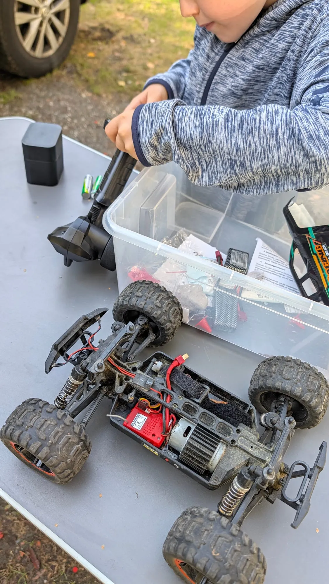 Blick von oben auf den geöffneten Buggy: Akku, Motor und Lenkgestänge liegen frei